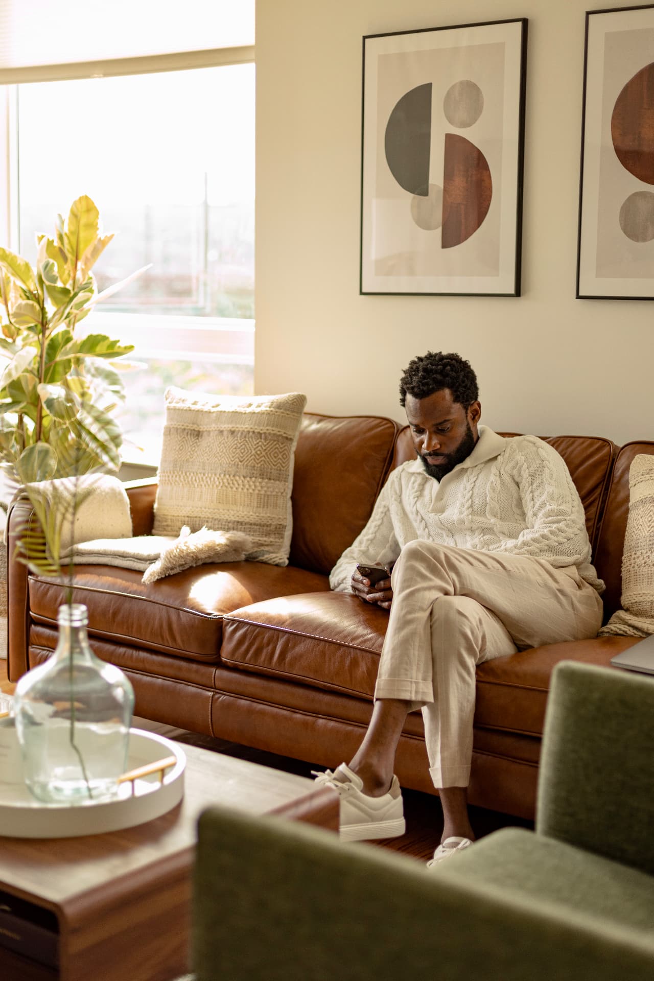 Emmanuel Bernard, founder of Preserve, sitting on a sofa looking at his phone